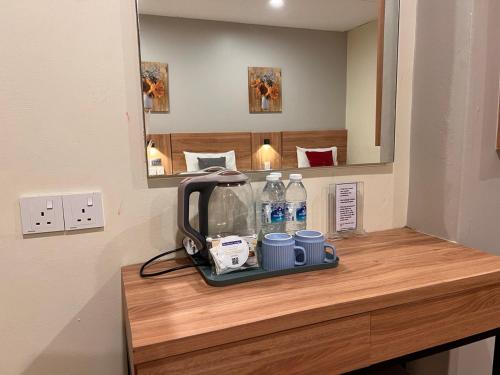a counter with a tea kettle and two mugs on it at Northern Lodge Hotel in Sungai Petani