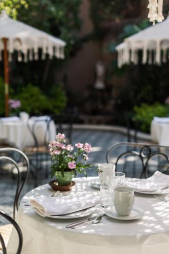 a table with plates and cups and flowers on it at Villa Ganz Boutique Hotel in Guadalajara