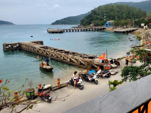 a group of people on motorcycles on a beach next to a pier at Tuan Thanh Homestay in Tân Hiệp