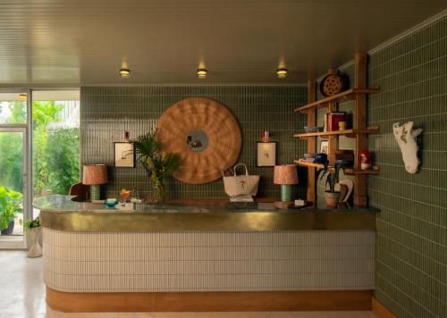 a bathroom with a counter with a mirror and green tiles at The Maidstone New Orleans in New Orleans
