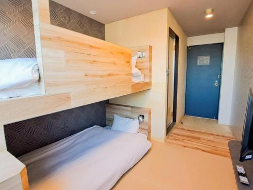 a small bedroom with a bed and a bunk room at Hotel Areaone Naruto in Naruto