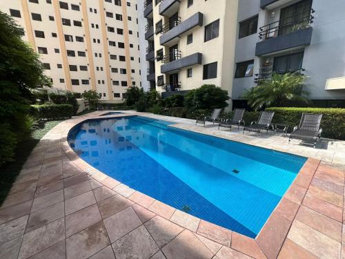 a large blue swimming pool in front of a building at Conforto e Estilo na Saúde-SP - Ar Condicionado e Garagem - CETRUS - SP EXPO in Sao Paulo
