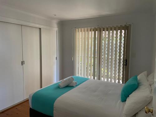 a bedroom with a large bed and a large window at Fishing Haven Holiday Park in Palmers Island