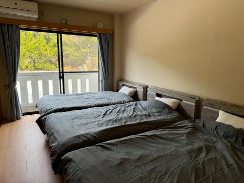上天草市にある波のたわむれの大きな窓のある部屋にベッドが2つある