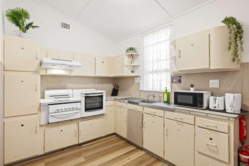 a kitchen with white cabinets and white appliances at Classic Double Room - Quaint Place in South Hurstville - Shared Bathroom in Sydney
