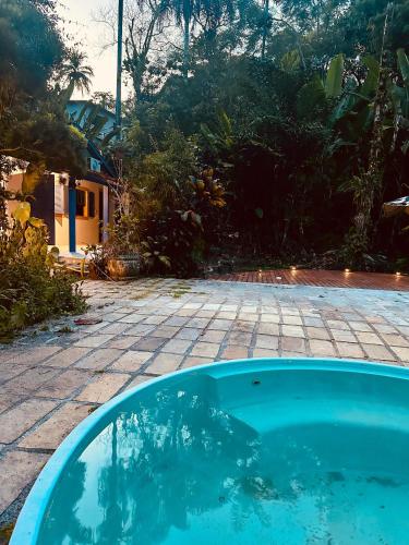 a swimming pool in a yard with a house at Recanto Serenare in Angra dos Reis