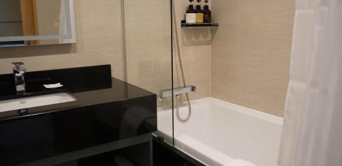 a bathroom with a tub and a sink and a shower at Stanford hotel Andong in Andong