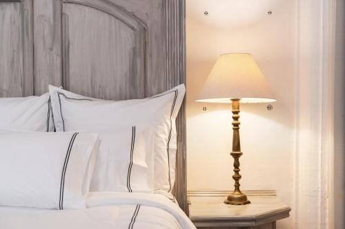 a lamp on a night stand next to a bed at Villa Ganz Boutique Hotel in Guadalajara