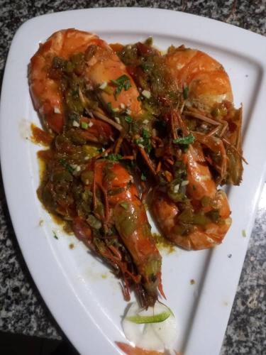 a white plate of food with meat and sauce at Kribi-Lodge in Kribi