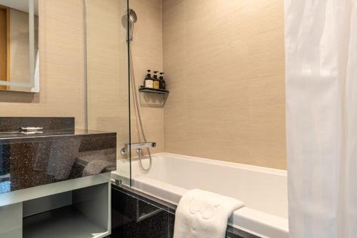 a bathroom with a bath tub and a sink at Stanford hotel Andong in Andong