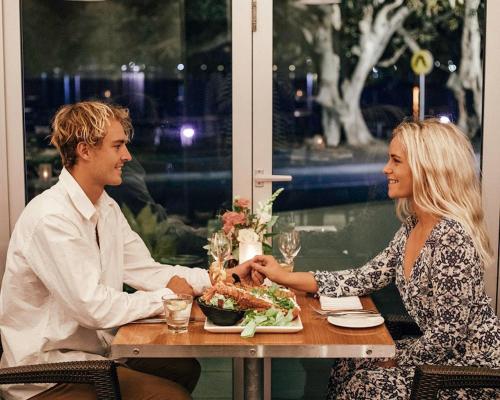 a man and woman sitting at a table with a plate of food at Port Lincoln Hotel in Port Lincoln