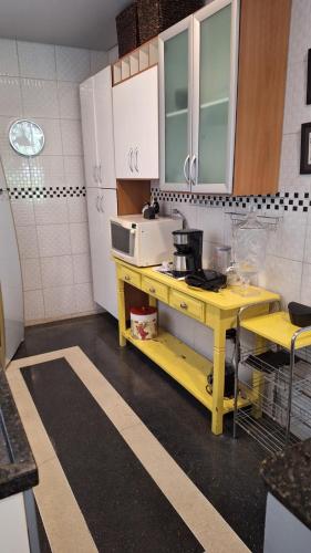 a kitchen with a yellow table in a kitchen at Casa Alto Da Boa Vista Com Piscina e Churrasqueira in São Paulo