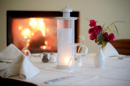 a table with a candle and flowers in vases at Les Jardins de Toumana in Triffa