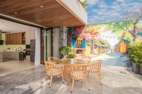 a dining room with a table and chairs and a kitchen at Mai Villa Hoi An - 3 steps to Night Market in Hoi An