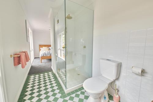 a bathroom with a toilet and a glass shower at The Palm House 200 meters to the beach in Torquay