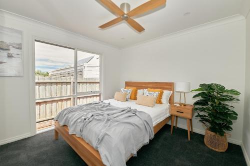 a bedroom with a bed and a large window at The Palm House 200 meters to the beach in Torquay