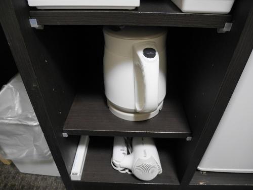a white appliance sitting on a shelf in a cabinet at Natural hot spring with sauna HOTEL GLAN Y's KOSHIGAYA in Koshigaya