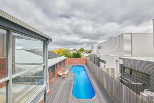 a swimming pool on the balcony of a building at The Palm House 200 meters to the beach in Torquay