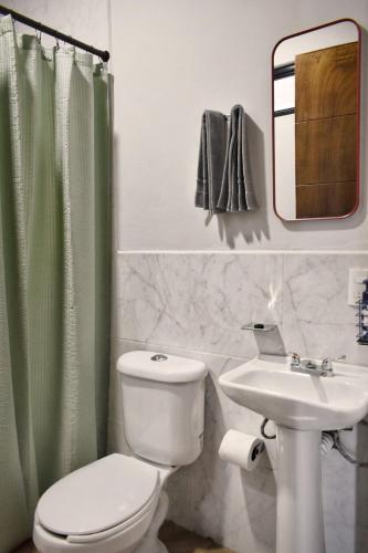 a bathroom with a toilet and a sink and a mirror at Departamento Apolo in Jamay