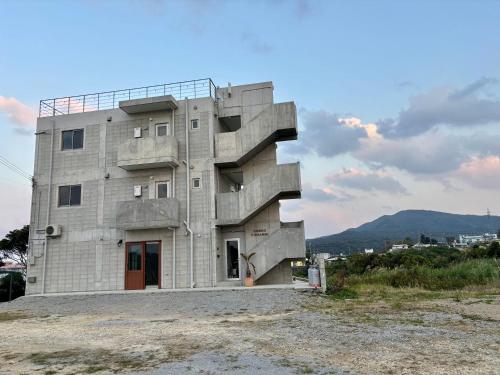 a building with a staircase on the side of it at CondoYumangi in Onna
