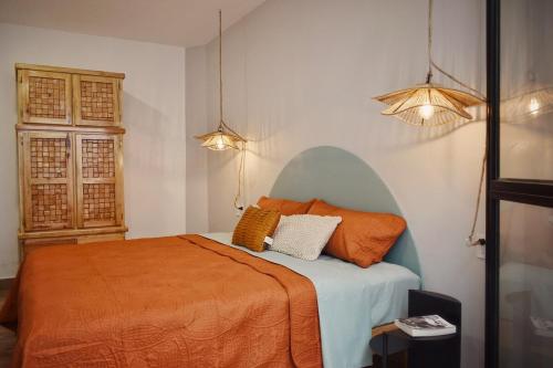 a bedroom with a bed with orange sheets and two pillows at Departamento Apolo in Jamay