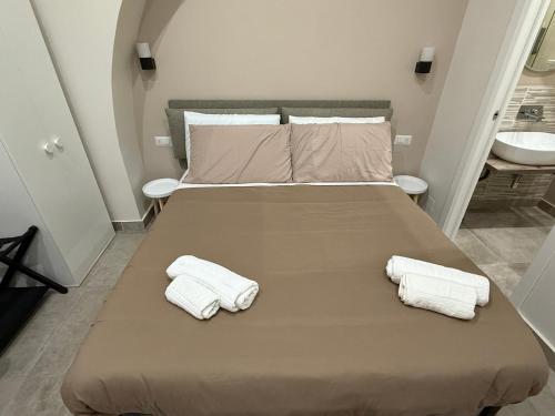 a bedroom with a bed with two towels on it at Stay In Naples - Arenaccia 211 Rooms and Suite in Naples