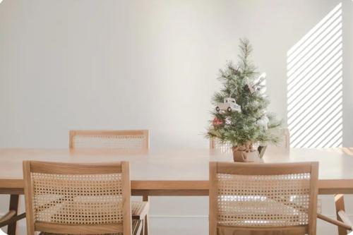 a dining room table with a christmas tree and two chairs at Outdoor Living at Its Finest in Auckland
