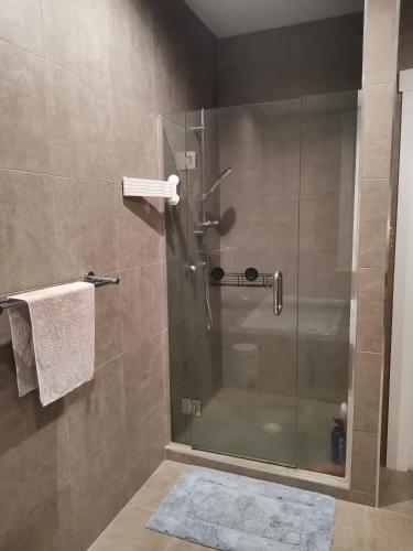 a shower with a glass door in a bathroom at Outdoor Living at Its Finest in Auckland