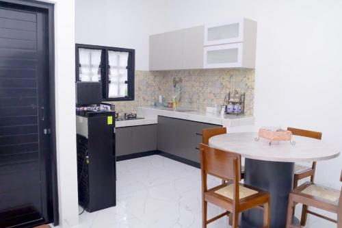 - une cuisine avec une table, une petite table et des chaises dans l'établissement Seruni Garden - Guesthouse Bandung, à Bandung