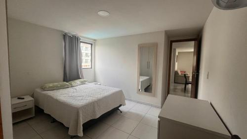 ein Schlafzimmer mit einem Bett und einem großen Spiegel in der Unterkunft Apartamento em Porto de Galinhas in Porto De Galinhas