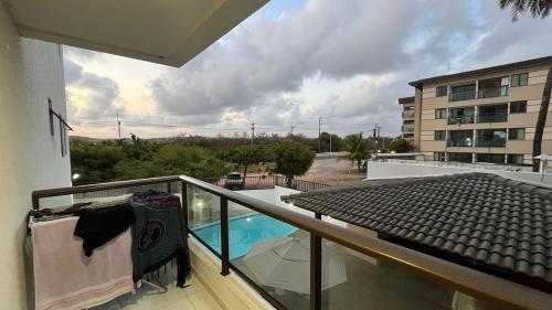 einen Balkon mit Poolblick auf einem Gebäude in der Unterkunft Apartamento em Porto de Galinhas in Porto De Galinhas