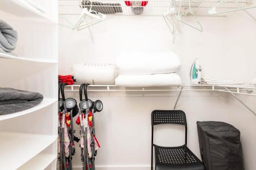 a walk in closet with a black chair in it at Sky-Rise Apartments in Los Angeles