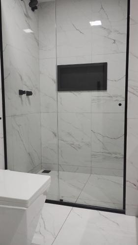 a bathroom with a glass shower with a sink at Eco paradise 134 in Cumbuco