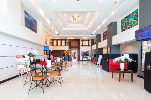マニラにあるHotel Sogo Santolanの椅子・テーブル・花の店ロビー