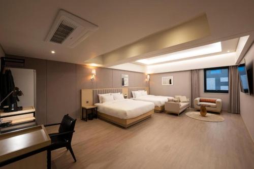 a large bedroom with a bed and a couch and a desk at Hound Hotel Yeonsan in Busan