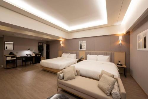 a hotel room with two beds and a couch at Hound Hotel Yeonsan in Busan