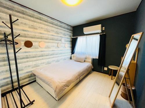 a small bedroom with a bed and a painting on the wall at Koguma Shizuka in Osaka