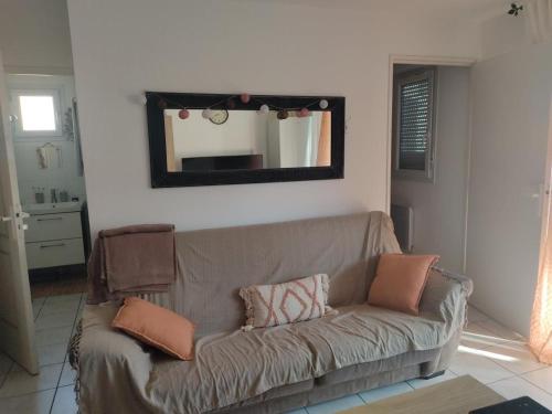 un salon avec un canapé et un miroir dans l'établissement Villa 4/6 pers climatisée avec piscine, WiFi & parking proche plage - FR-1-796-85, à Gruissan