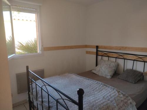une chambre avec un lit et une fenêtre dans l'établissement Villa 4/6 pers climatisée avec piscine, WiFi & parking proche plage - FR-1-796-85, à Gruissan