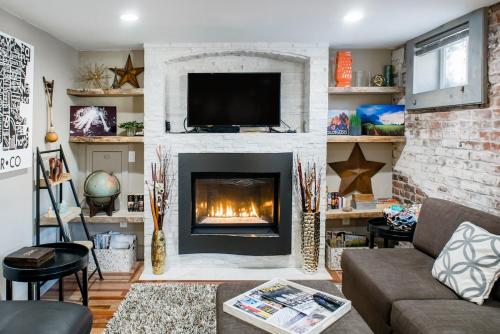 a living room with a fireplace with a tv at Designer Apartment in a Historic 1901 Downtown Area Mansion in Denver