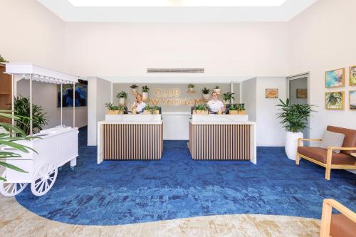 a lobby with two tables with plants on them at Club Wyndham Kirra Beach in Gold Coast
