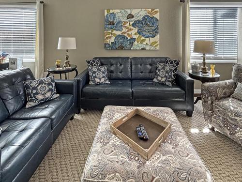 a living room with black leather couches and a table at Home Away From Home home in Grand Junction