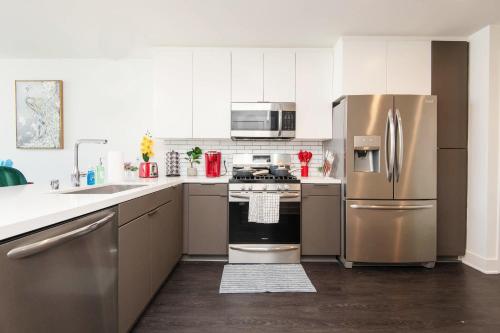a kitchen with stainless steel appliances and white cabinets at Sky-Rise Apartments in Los Angeles