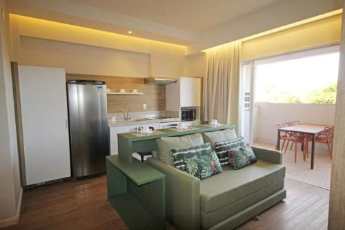 a living room with a couch and a kitchen at Olímpia Beach Park Ap e Ingressos in Olímpia