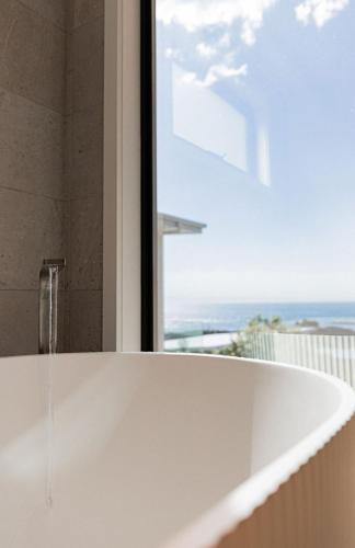 a bath tub with a view of the ocean at Surfscape in Bicheno
