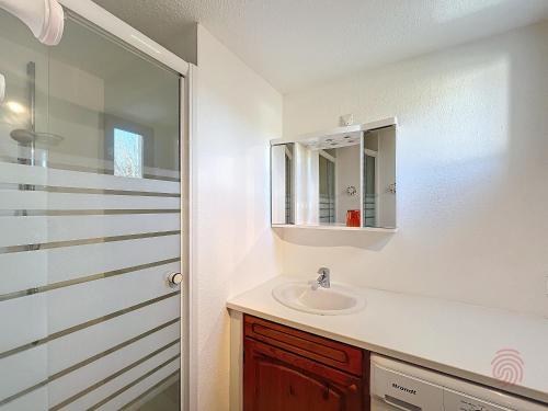une salle de bain avec un lavabo et un miroir dans l'établissement Bel F2 avec terrasse à 650m des Thermes de Lamalou, animaux acceptés, WIFI, proche golf et randonnées - FR-1-451-146, à Lamalou-les-Bains