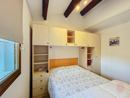 une petite chambre avec un lit et une fenêtre dans l'établissement Bel F2 avec terrasse à 650m des Thermes de Lamalou, animaux acceptés, WIFI, proche golf et randonnées - FR-1-451-146, à Lamalou-les-Bains