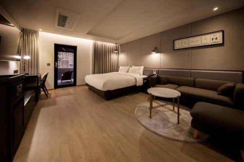 a hotel room with a bed and a couch at Hound Hotel Yeonsan in Busan