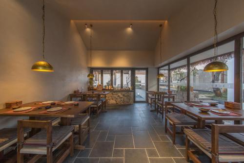 丽江Lijiang Liuji Rizhao Jinshan View Guesthouse的餐厅设有木桌、长凳和窗户。