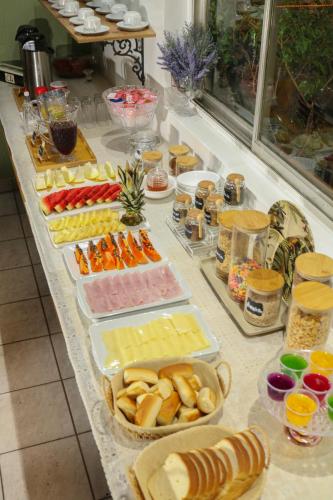 un buffet avec différents types de nourriture sur une table dans l'établissement Pousada dos Franceses, à São Paulo